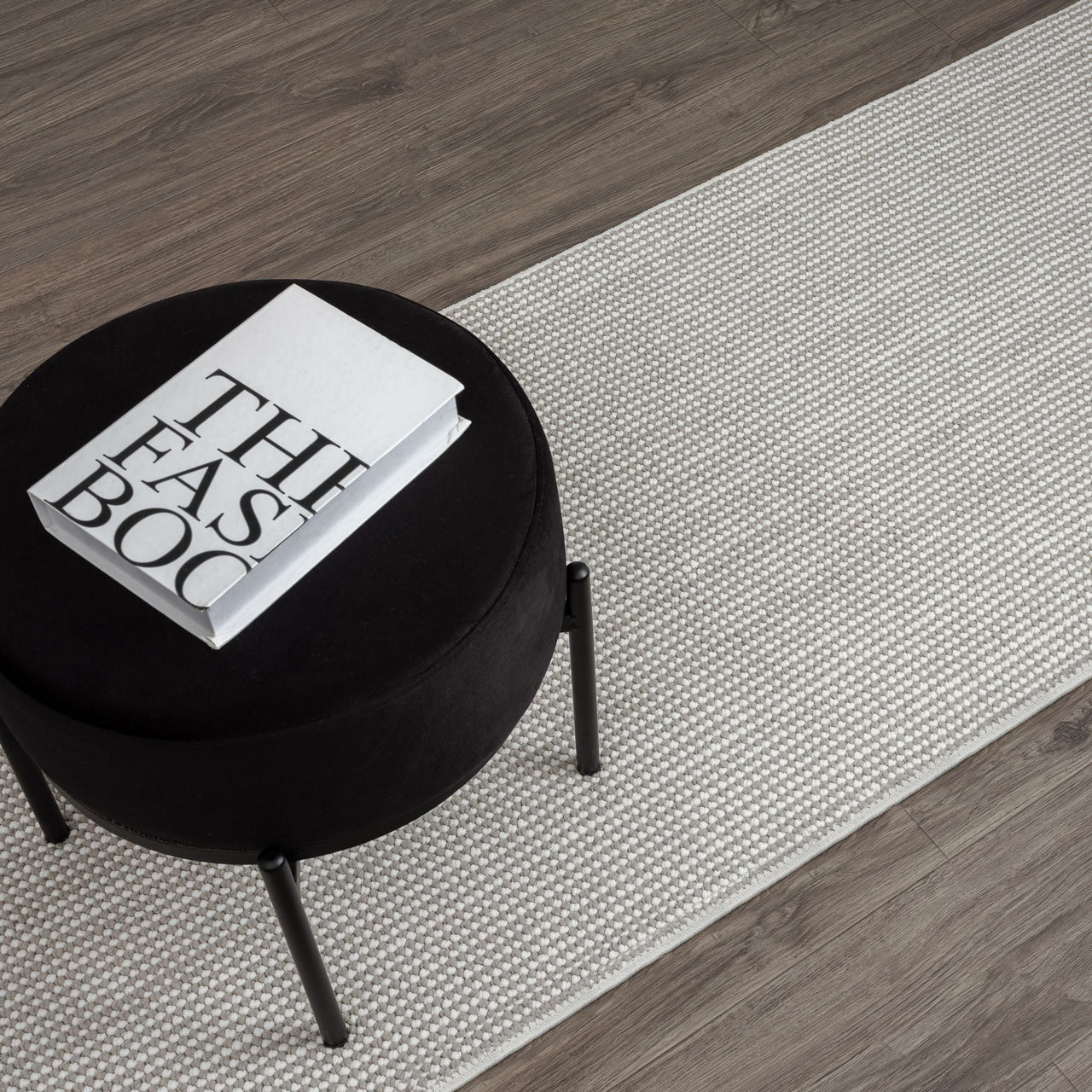 Grey flatweave runner rug with subtle geometric pattern on wood floor.