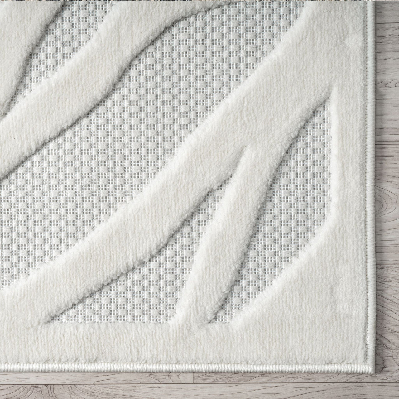 Ivory modern rug with raised geometric white pattern and textured polypropylene pile.