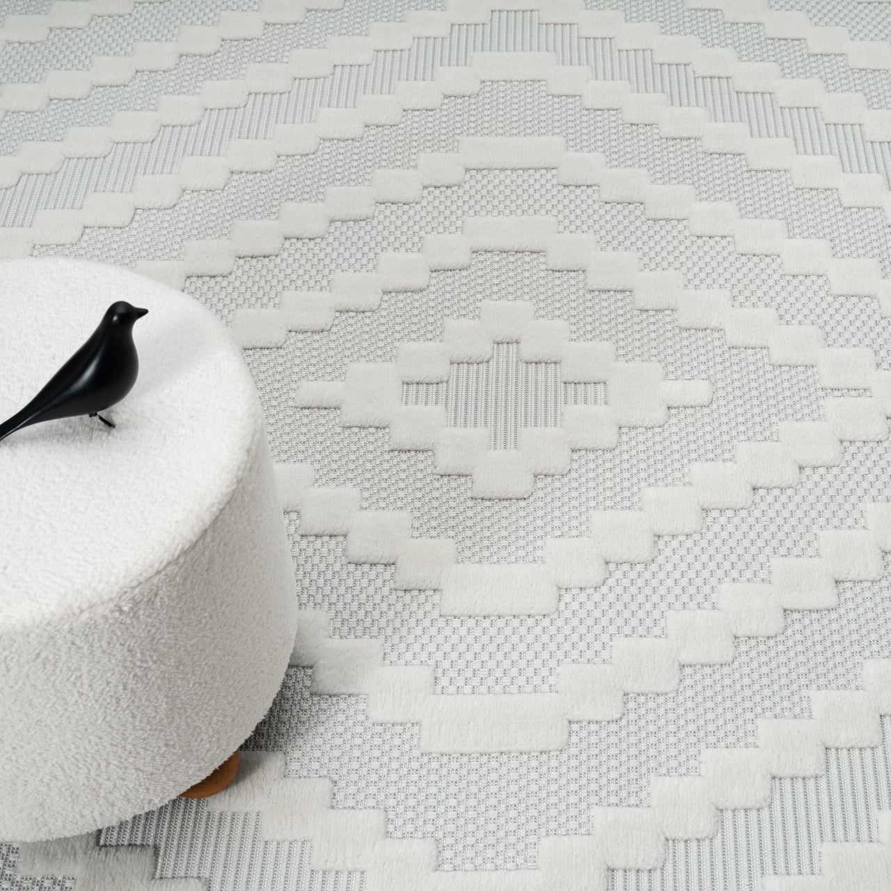 Cream geometric patterned modern rug with textured pile and subtle neutral tones.