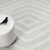 Cream geometric patterned modern rug with textured pile and subtle neutral tones.