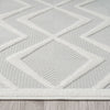White modern rug with raised textured geometric diamond pattern on a flat woven background.
