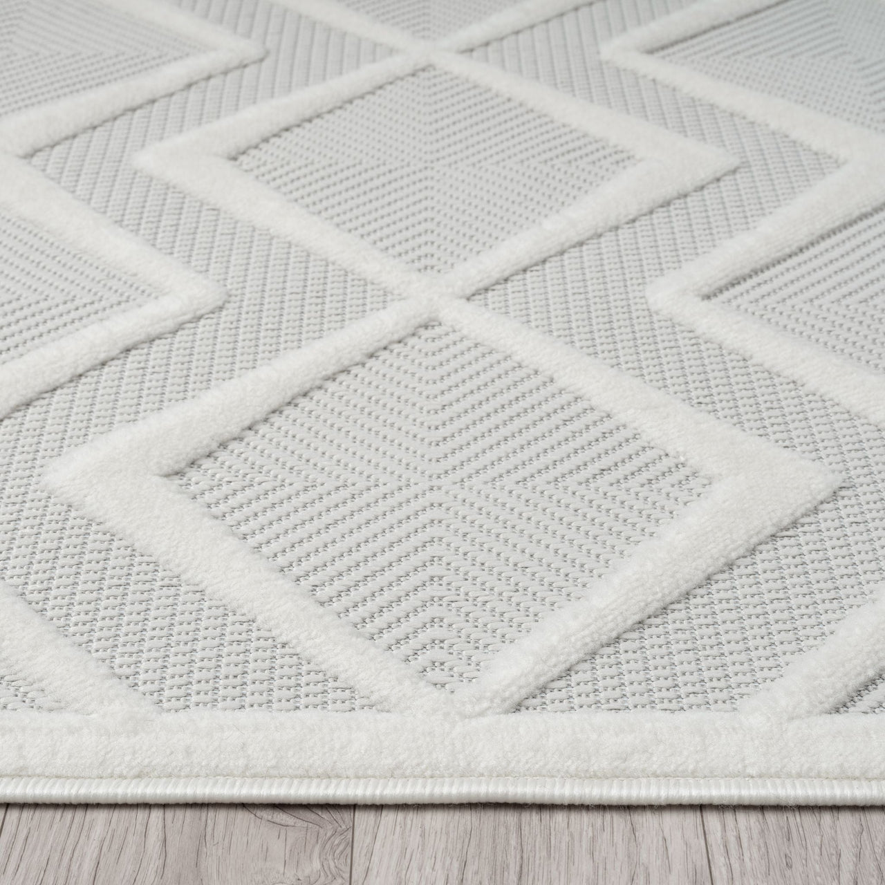 White modern rug with raised textured geometric diamond pattern on a flat woven background.