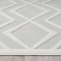 White modern rug with raised textured geometric diamond pattern on a flat woven background.