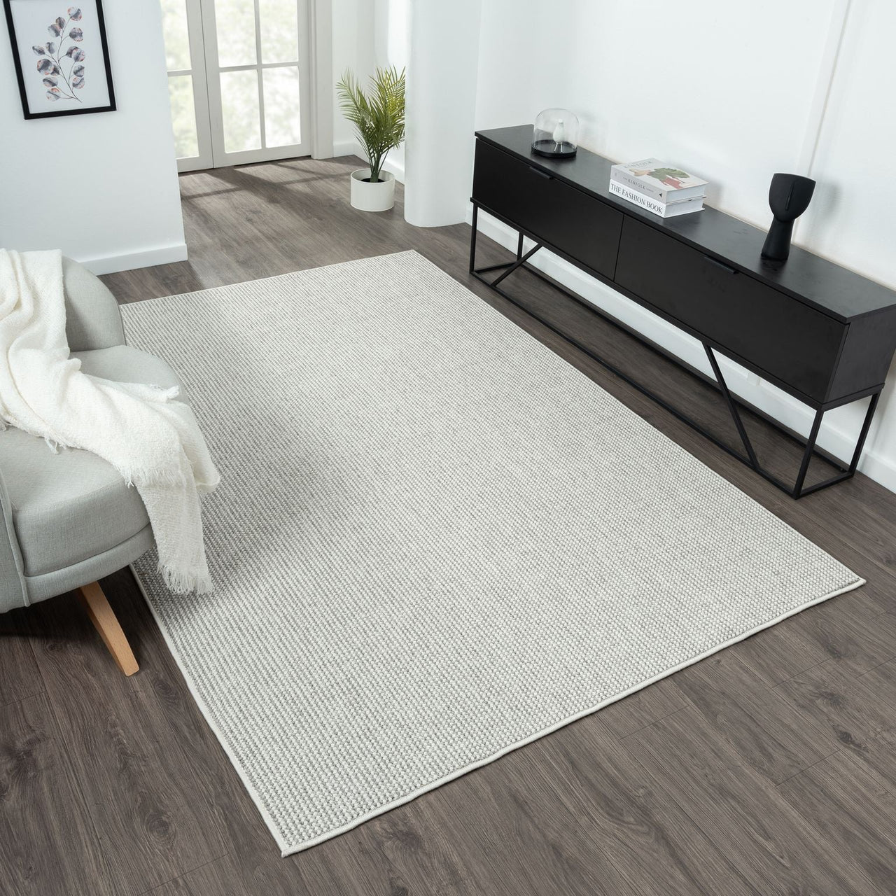 Silver grey flatweave rug with subtle linear texture in modern living room setting.