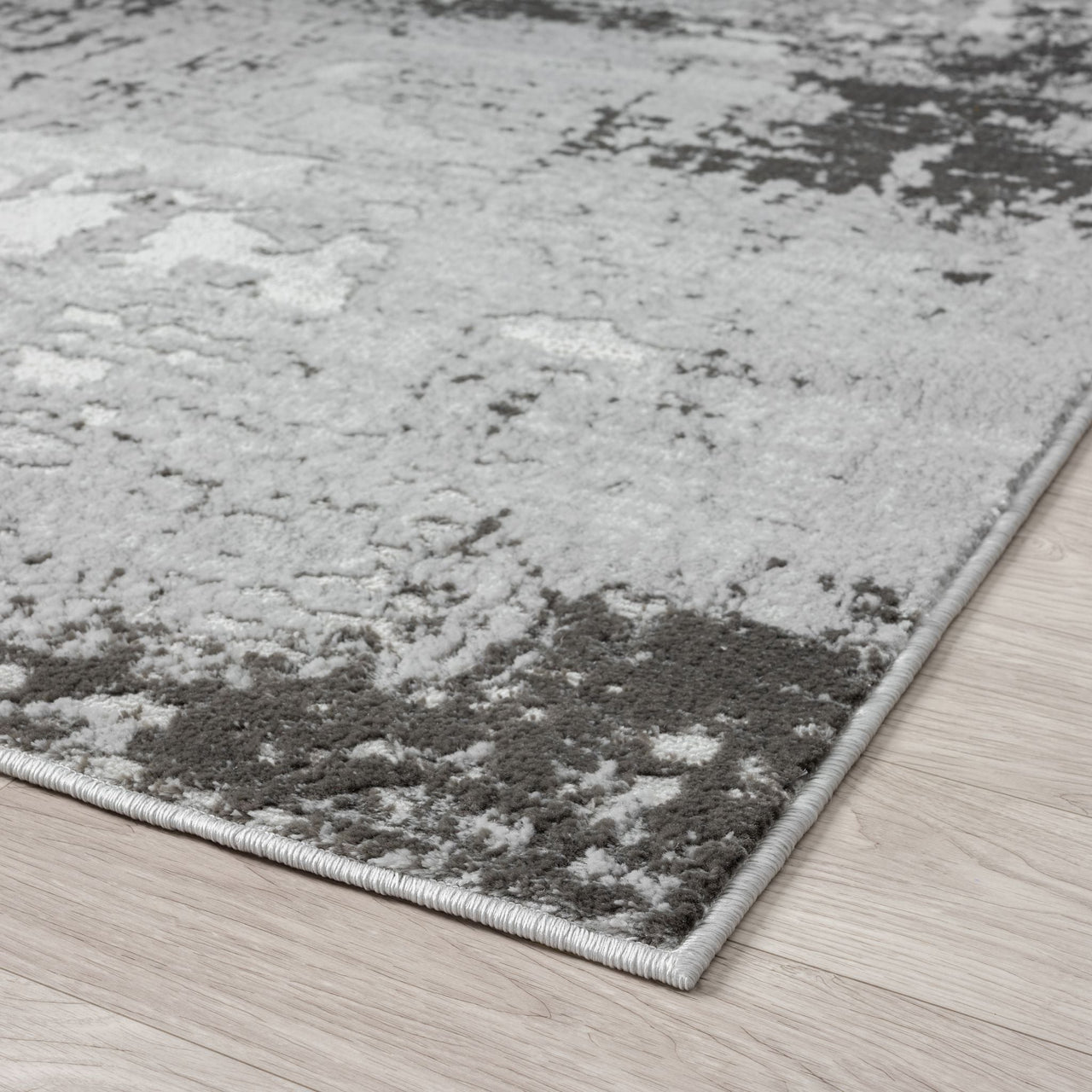 Gray and white textured area rug on a wooden floor