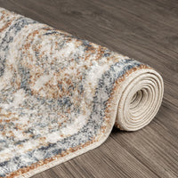 Rolled coral runner rug with abstract multi-colored pattern in gray, beige, and orange tones on hardwood floor.