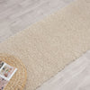 Beige modern shaggy runner rug with soft polyester fibers on light wood floor.