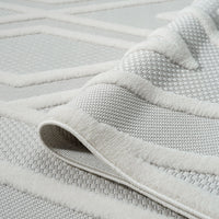 Grey and white modern runner rug with raised geometric pattern and textured polypropylene pile.