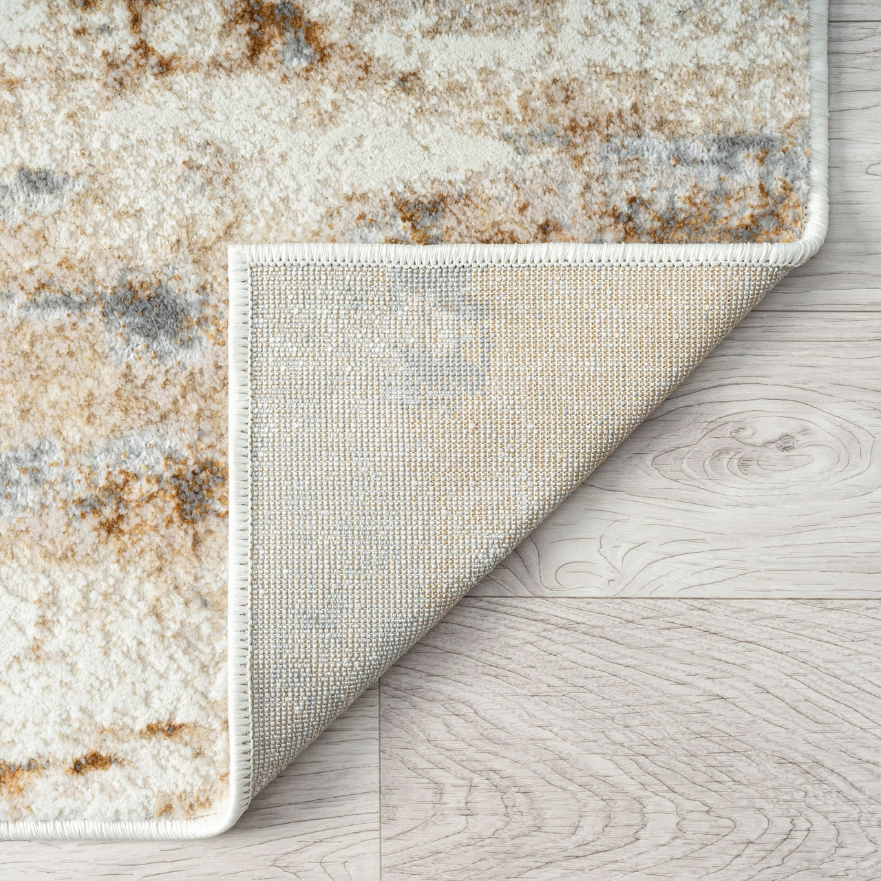 Close-up of a textured rug corner on a wooden floor