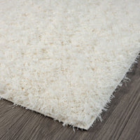 Cream-colored modern shaggy runner rug with thick polyester pile on dark hardwood floor.