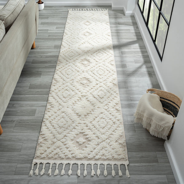 Beige and white runner rug with modern geometric diamond pattern and fringed edges on hardwood floor.