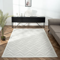 White geometric patterned modern rug with textured diamond design on hardwood floor.