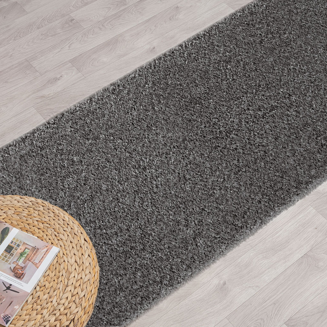 Grey shaggy runner rug with dense pile on light wood flooring next to a woven round mat.