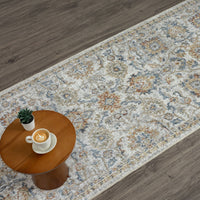 Multi-colored pearl runner rug with intricate floral and geometric patterns on gray hardwood floor.