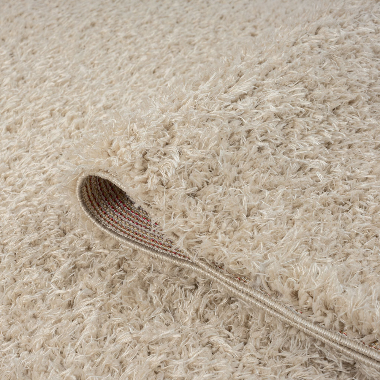 Beige modern shaggy runner rug with thick polyester fibers and textured pile, close-up detail.