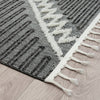 Grey and white runner rug with geometric zigzag and striped pattern, textured pile, fringed edges.
