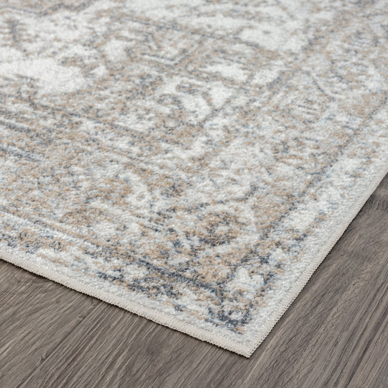 Beige and gray transitional runner rug with distressed floral pattern and subtle textured details on hardwood floor.