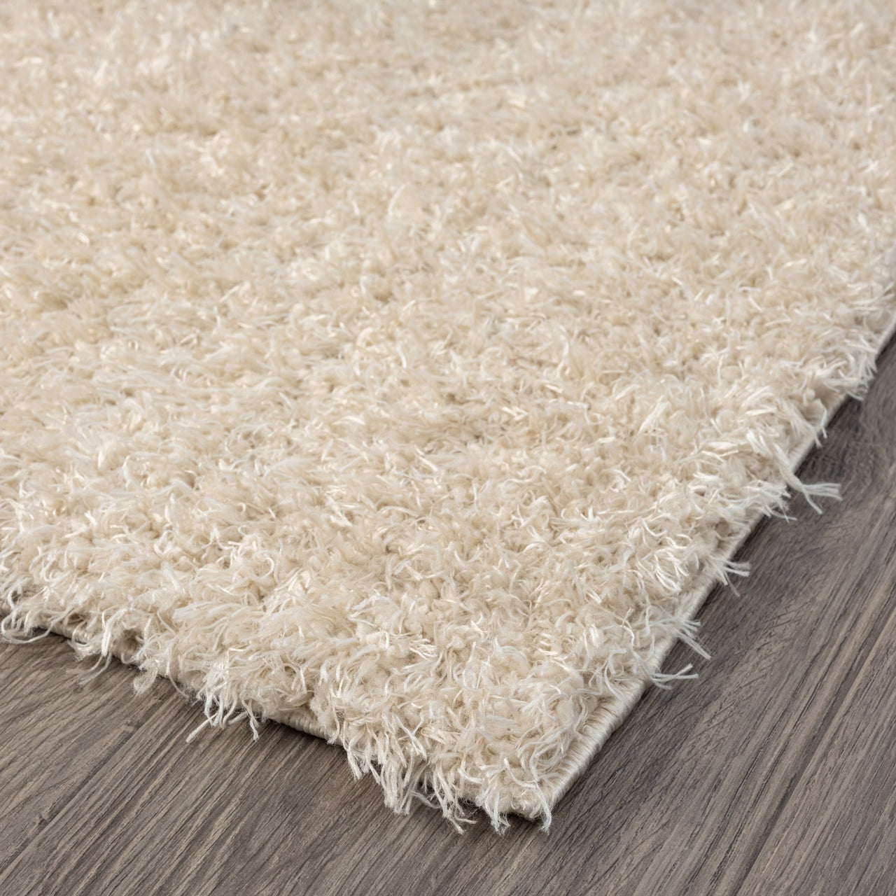 Beige modern shaggy runner rug with soft polyester fibers on dark wood floor.