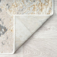 Beige and gray multi-colored geometric patterned runner rug with a cream edge on light wood floor.