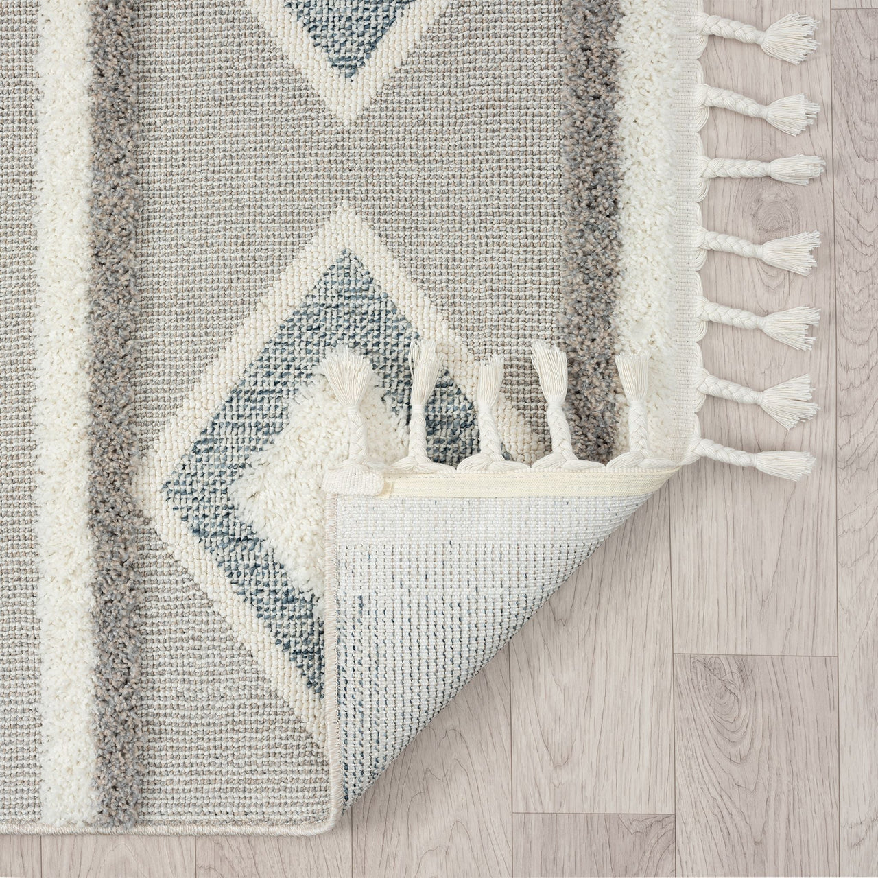 Grey and beige runner rug with modern geometric diamond pattern and white fringed edges.