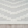 Cream runner rug with textured geometric stepped pattern on a light beige background.