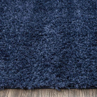 Navy blue modern shaggy runner rug with dense polyester fibers on wooden floor.