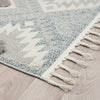 Grey and cream geometric patterned runner rug with textured pile and fringed edges on light wood floor.