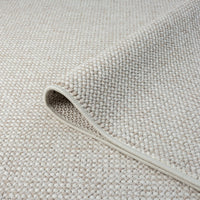 Beige flatweave rug with subtle geometric pattern and tight, low-shedding weave.