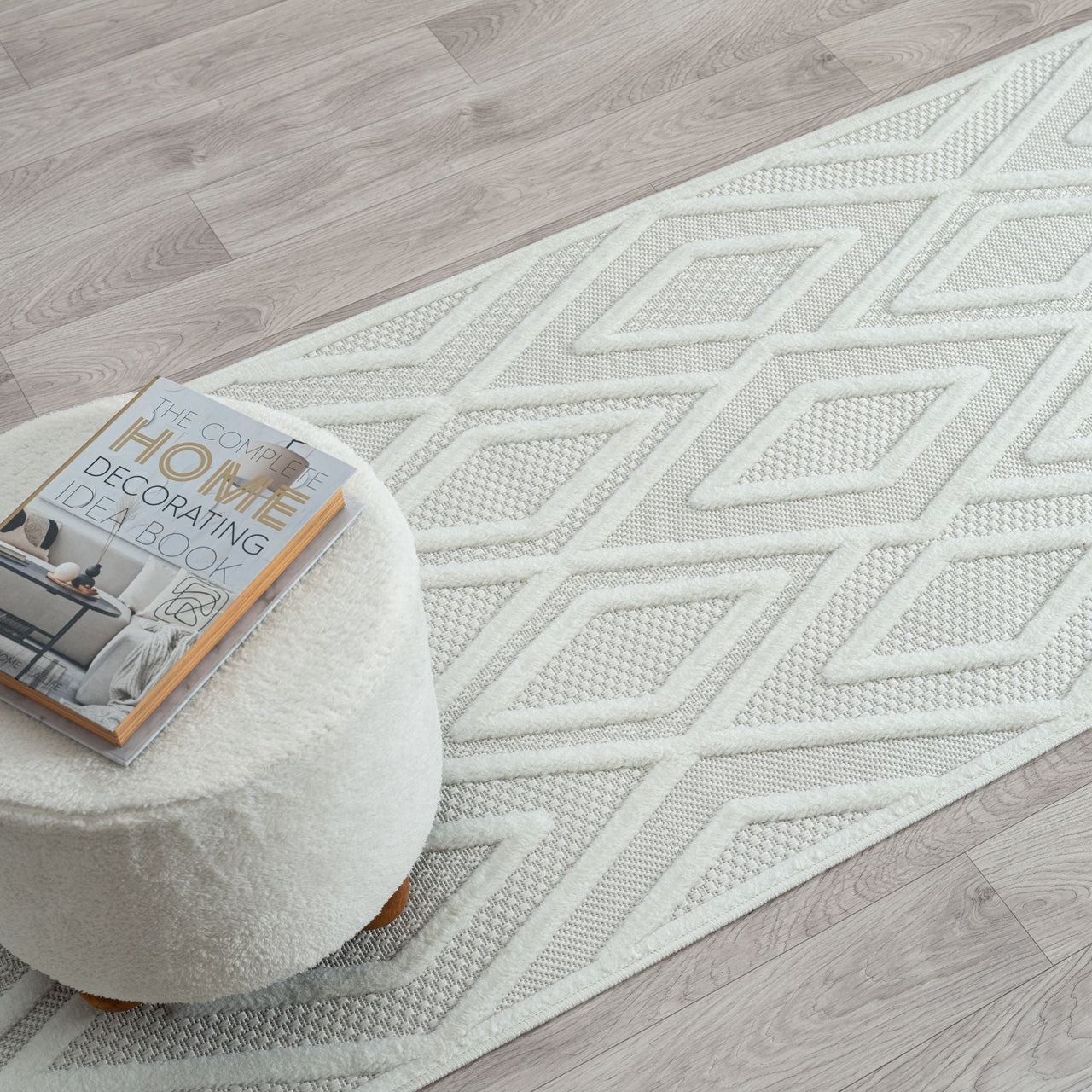 Grey and white runner rug with textured diamond geometric pattern on light neutral background.