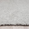 Light grey modern shaggy runner rug with dense polyester pile on wood floor.