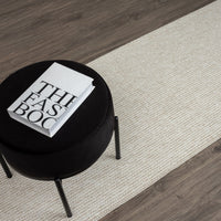 Beige flatweave runner rug with subtle geometric pattern on dark wood floor.