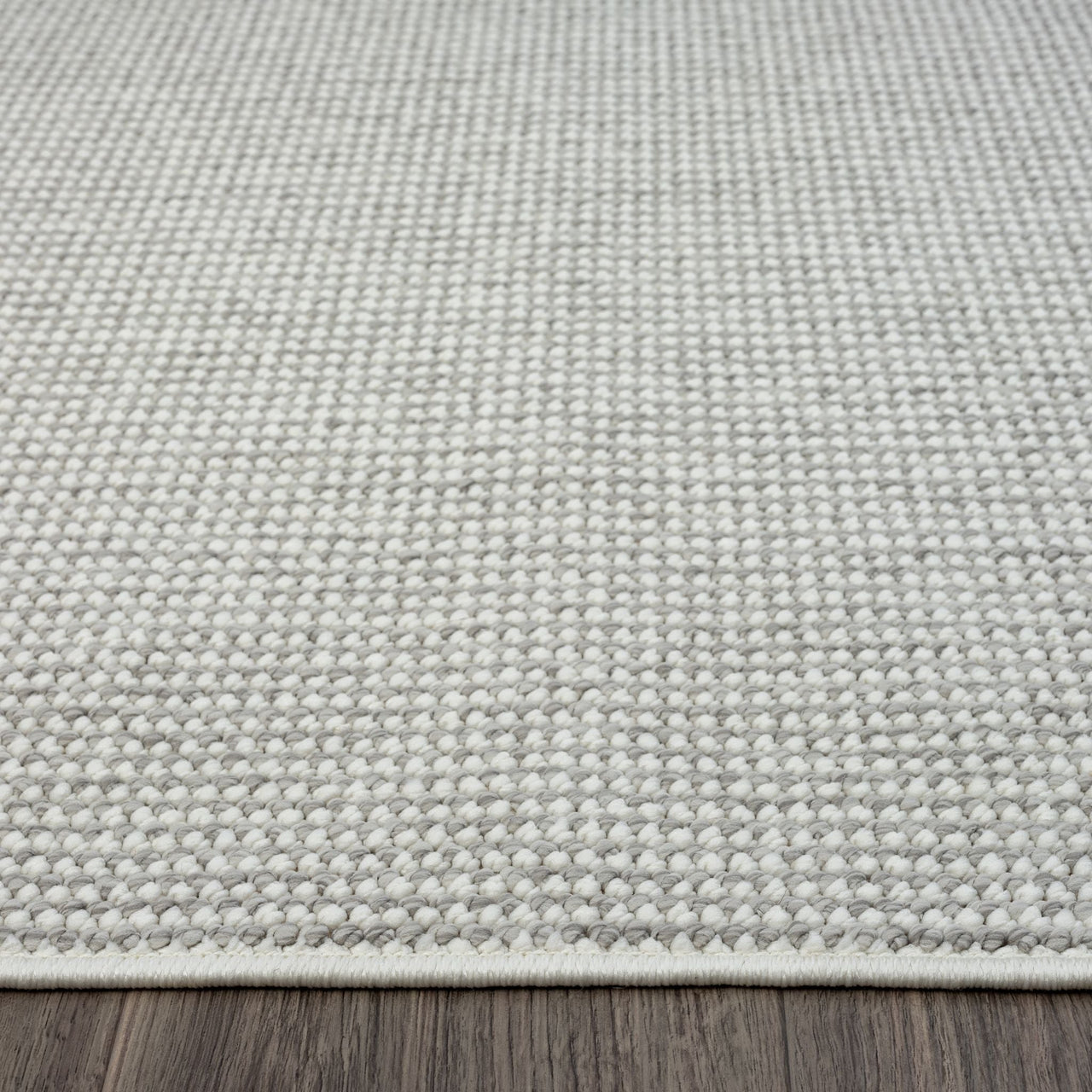 Silver grey flatweave modern rug with subtle textured weave on wooden floor.