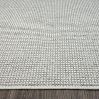 Silver grey flatweave modern rug with subtle textured weave on wooden floor.