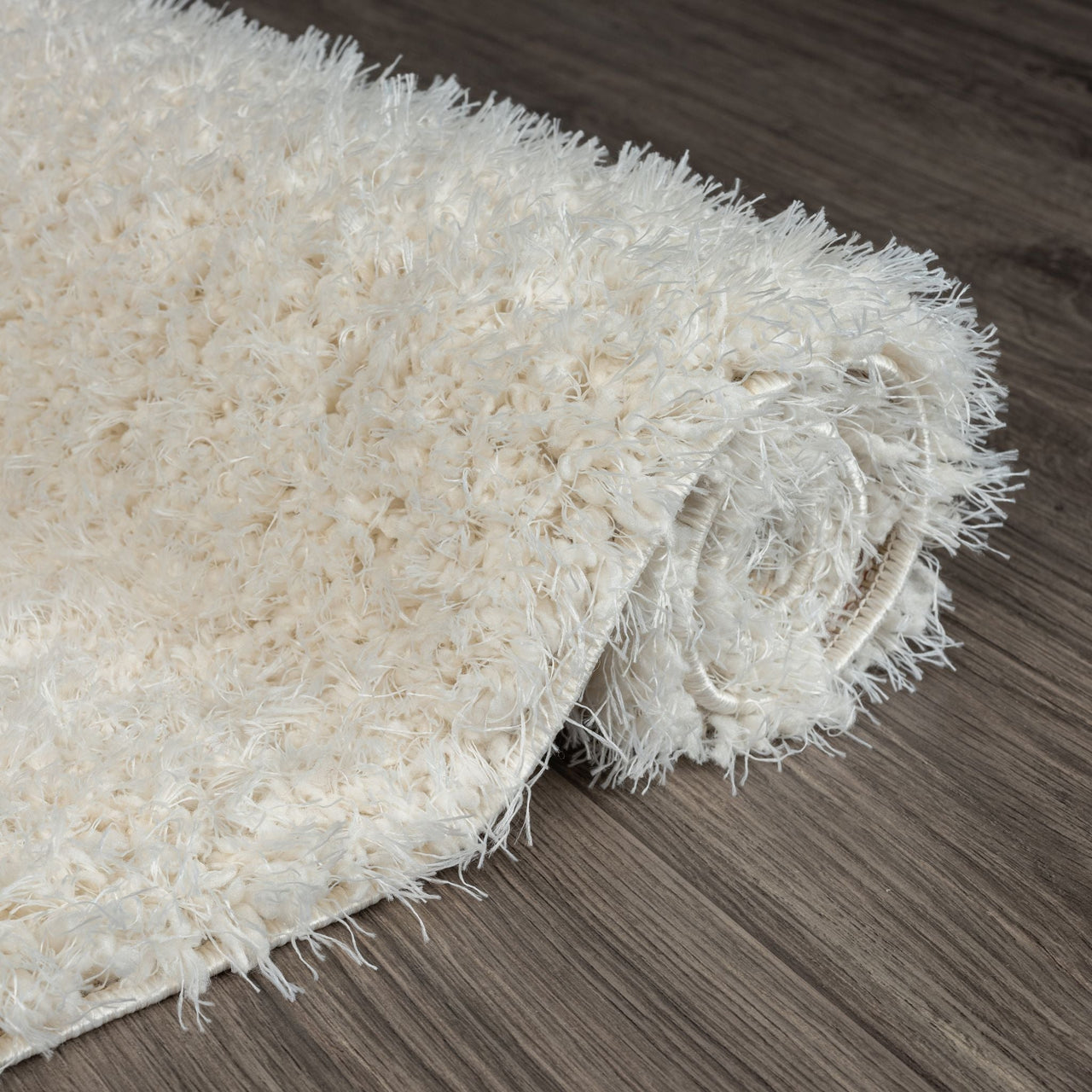 Cream-colored modern shaggy runner rug with thick, soft polyester fibers on dark hardwood floor.