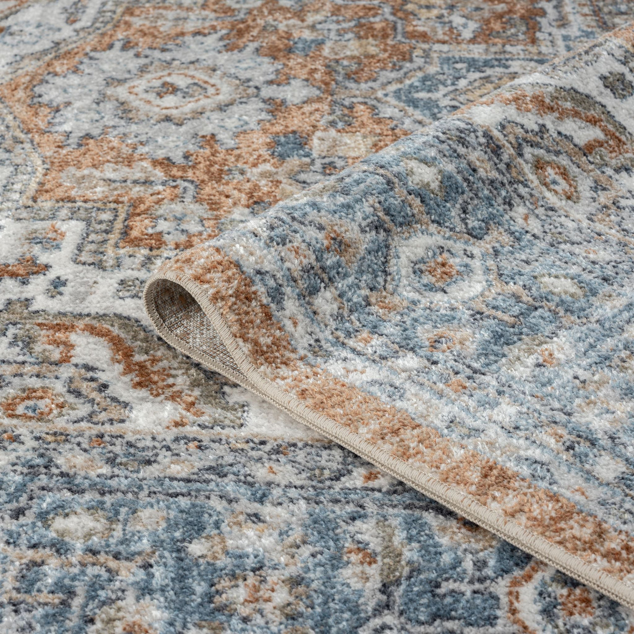 Blue multi-coloured transitional rug with intricate geometric and floral patterns, soft pile, machine washable polyester.