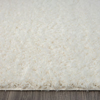 Cream-colored modern shaggy runner rug with soft, plush polyester fibers and thick pile texture.