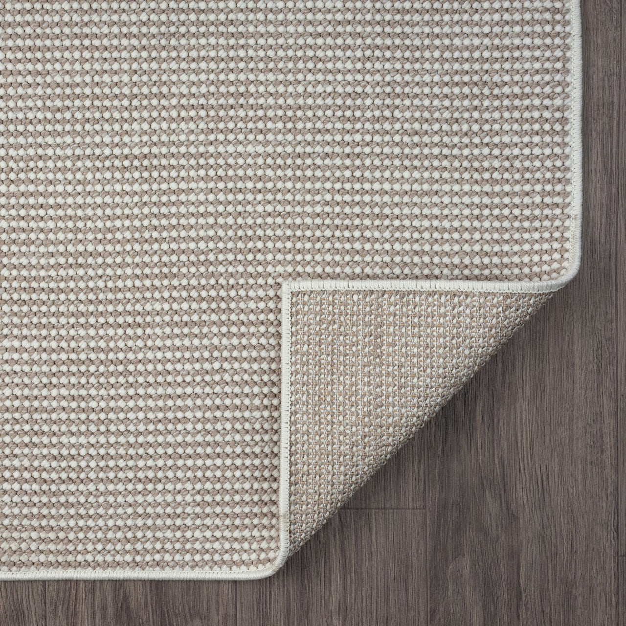 Beige flatweave runner rug with subtle geometric pattern and neatly bound edges on dark floor.