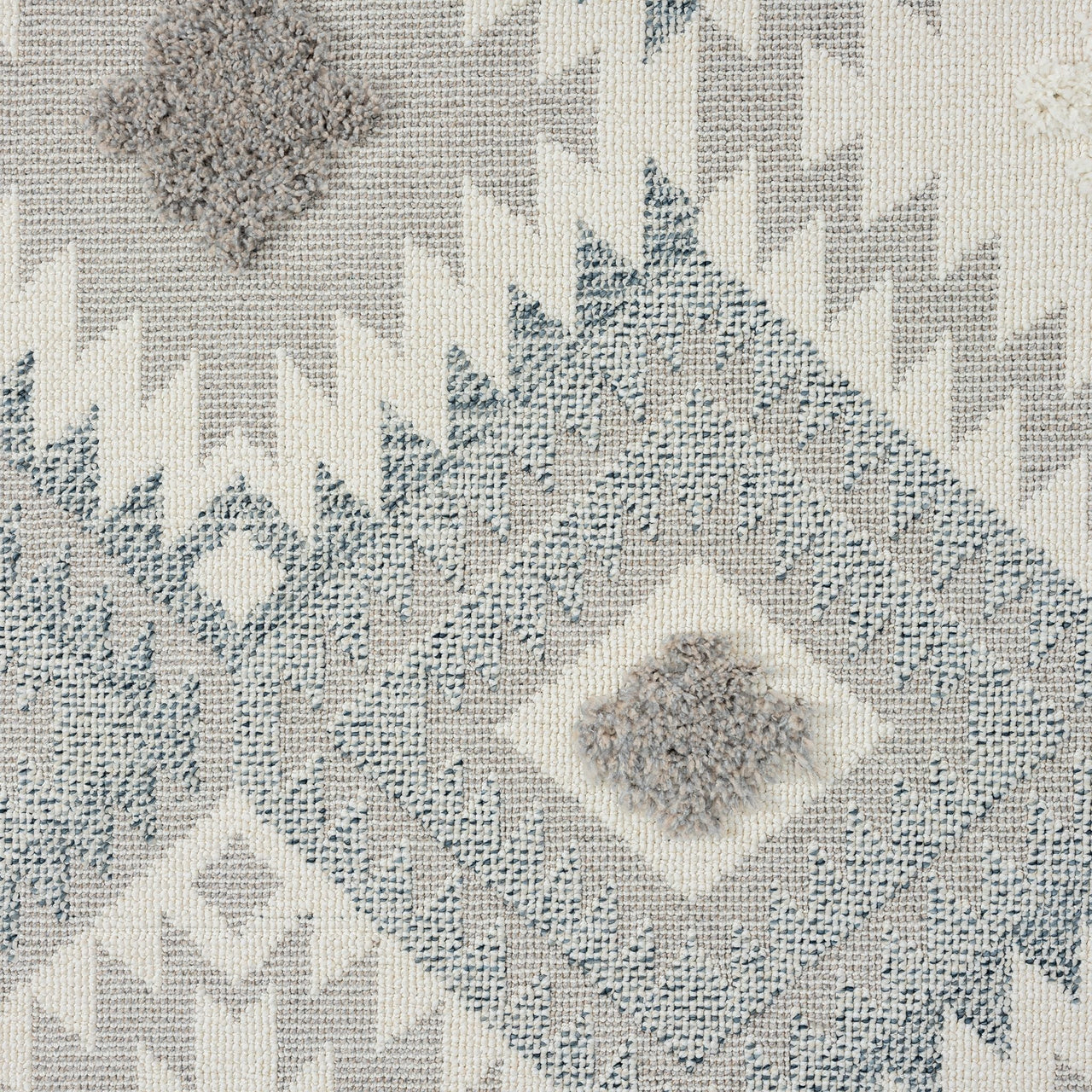 Grey and cream runner rug with modern geometric diamond and zigzag patterns and textured pile.