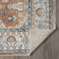 Modern multi-colored runner rug with intricate geometric and floral patterns in blue, orange, and beige tones, folded corner .