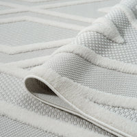 Grey and white geometric patterned rug with textured polypropylene pile, modern design.