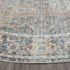 Round coral and beige patterned rug with subtle distressed detailing on hardwood floor.