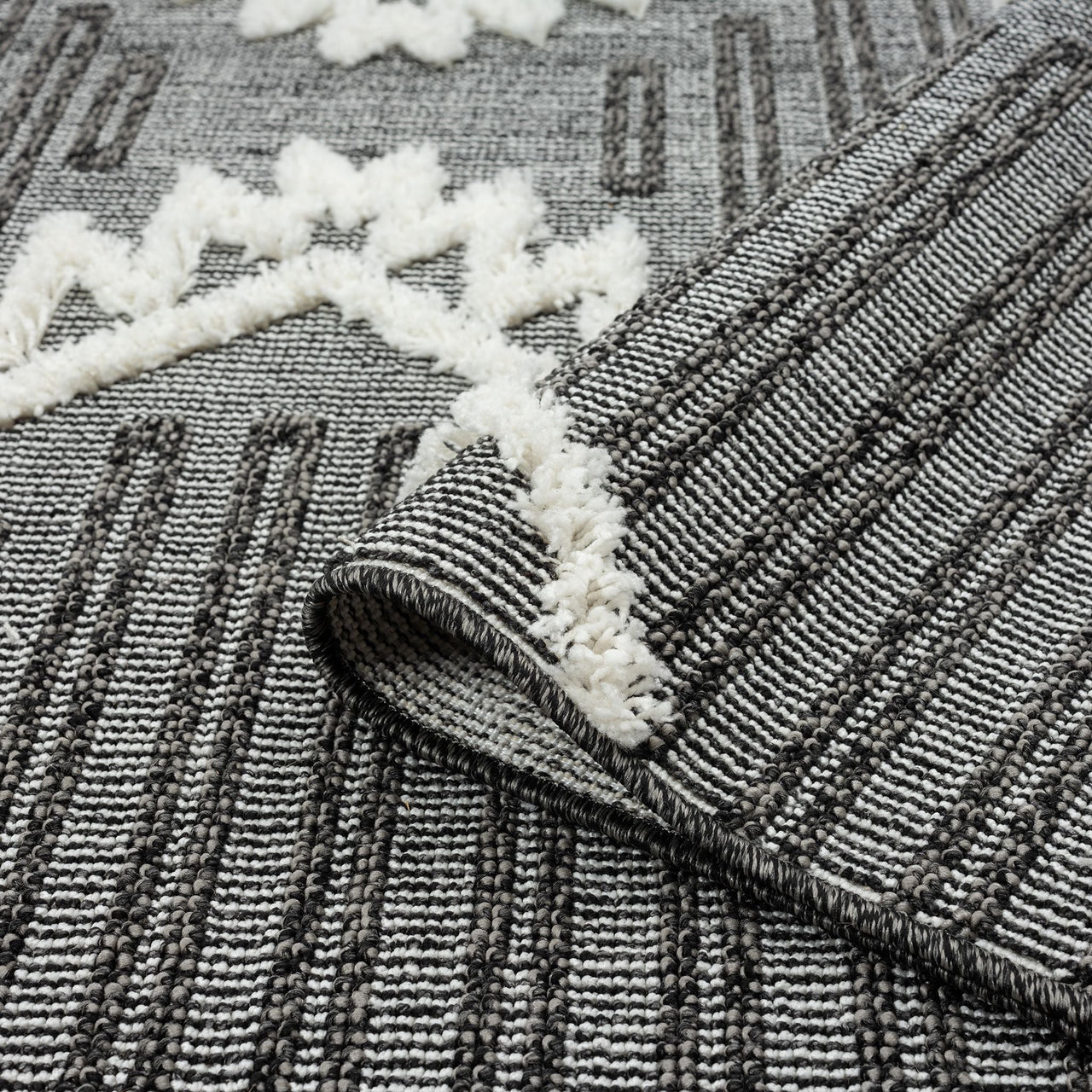Grey and white runner rug with textured geometric patterns and fringed edges.