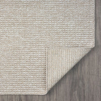 Taupe flatweave rug with subtle texture and clean edges on wooden floor.