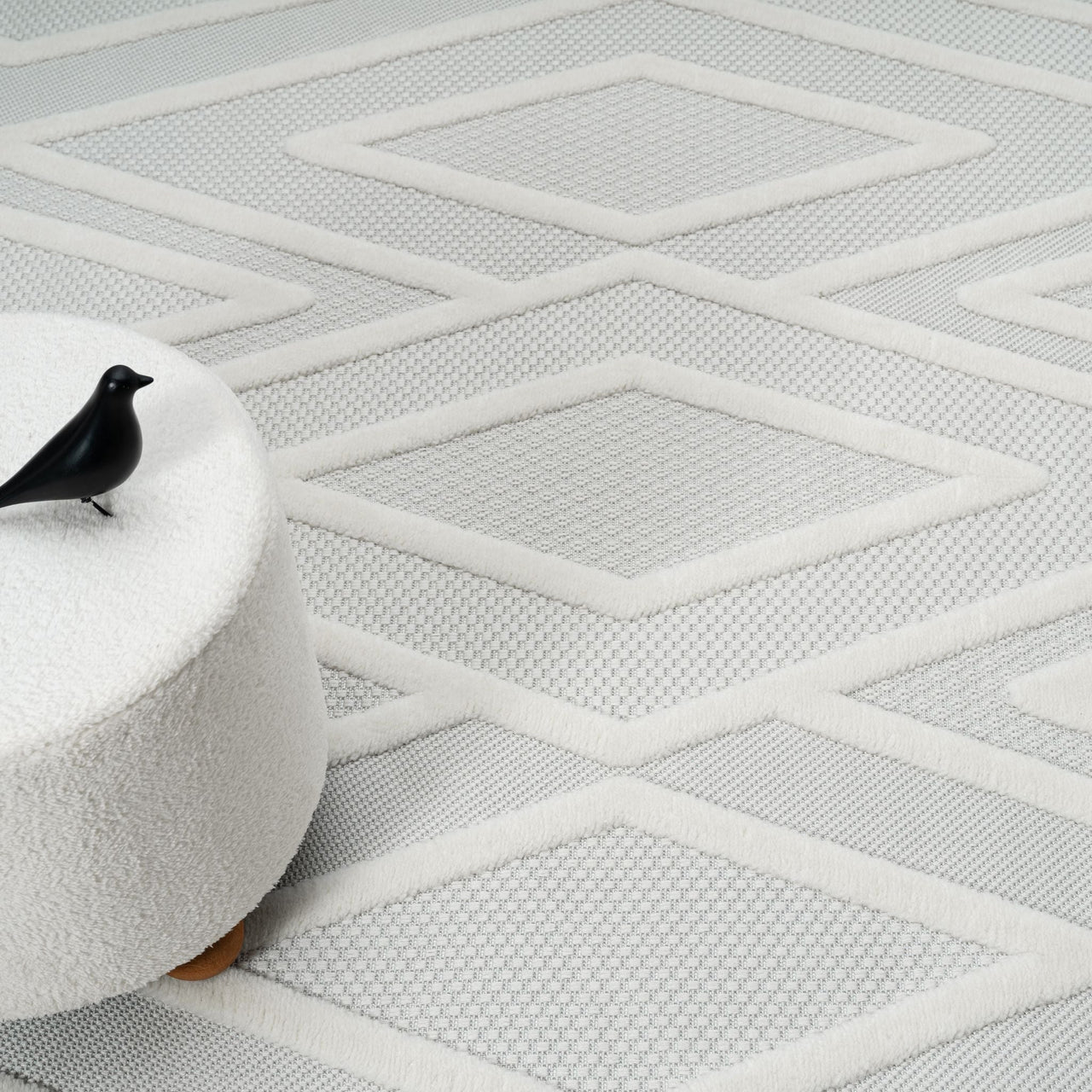 Grey and white geometric patterned rug with textured polypropylene pile and diamond shapes.