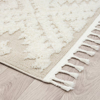 Beige and white modern geometric patterned runner rug with textured pile and fringed edges.