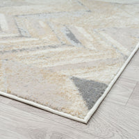 Modern runner rug with abstract geometric pattern in beige, gray, and cream tones on light flooring.