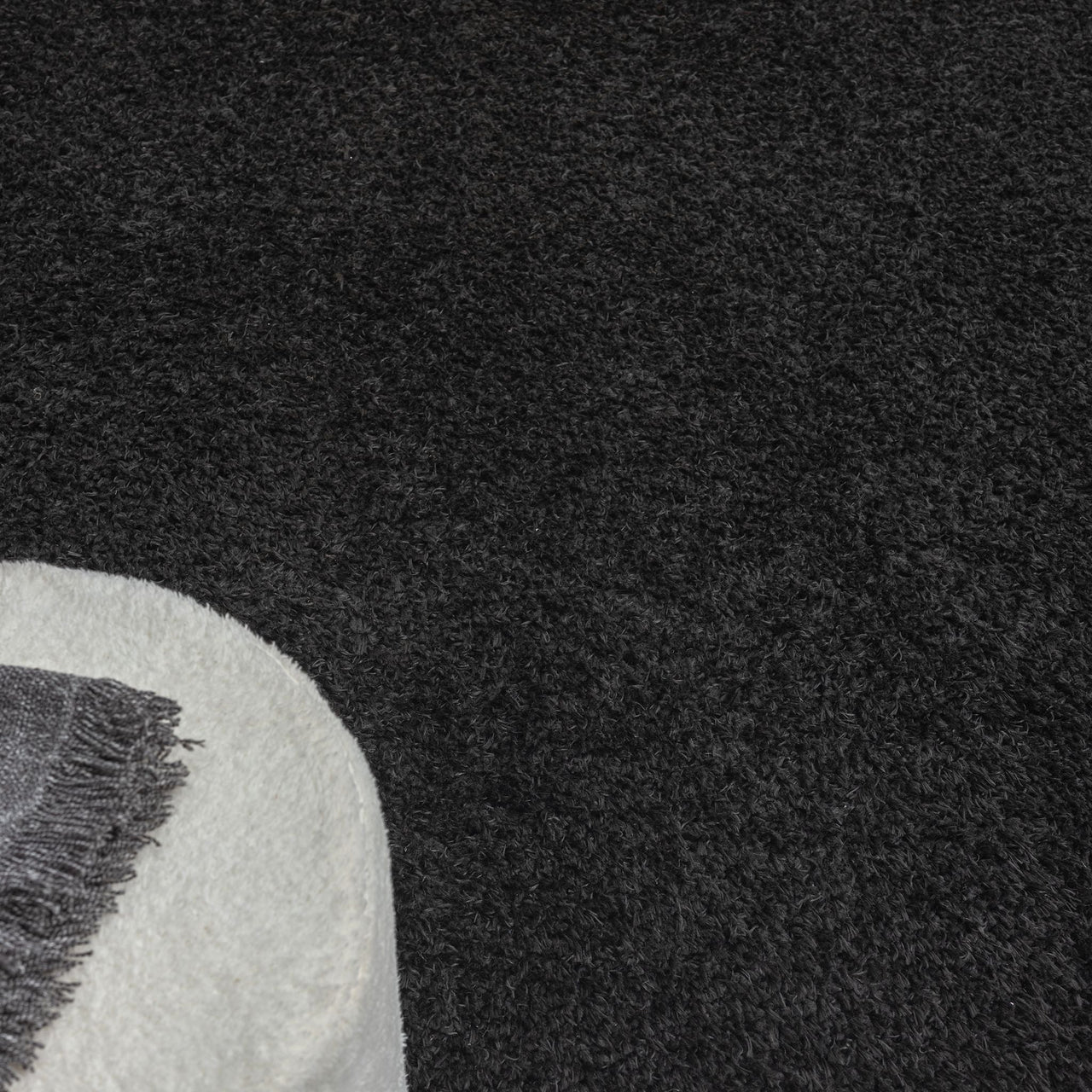 Black modern shaggy rug with dense, soft polyester pile and textured surface.