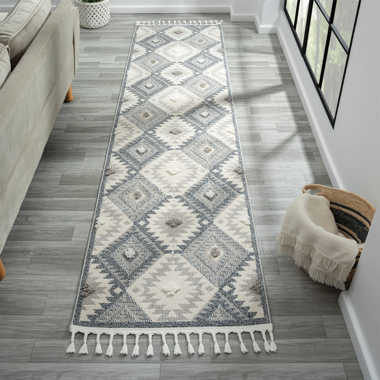 Grey and cream runner rug with modern geometric diamond pattern and fringed edges.