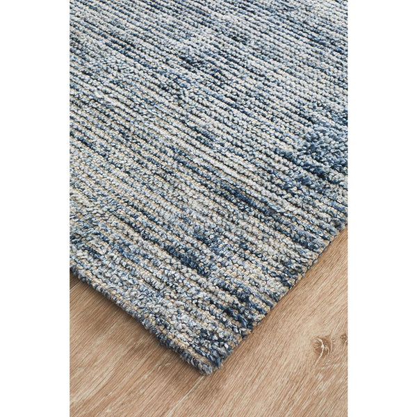 Indigo blue loop pile rug with textured modern pattern on light wood floor.