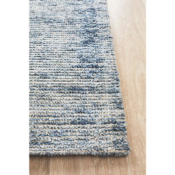 Indigo blue and white modern cut loop pile rayon cotton rug on light wood floor.